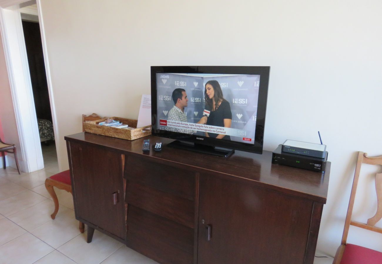 Sala de estar ampla e confortável com sofá, TV e mesa de jantar.