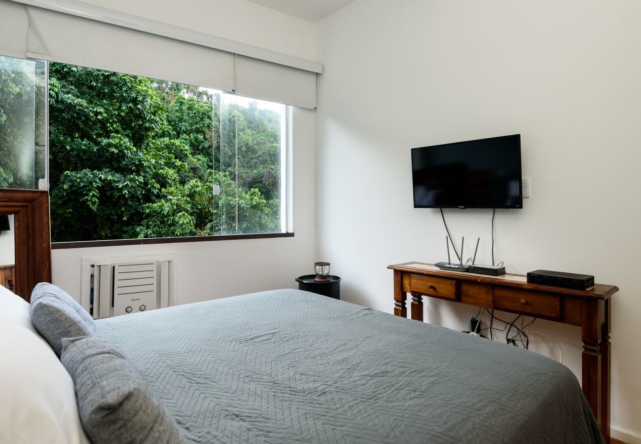 Dormitorio con cama de matrimonio y TV.