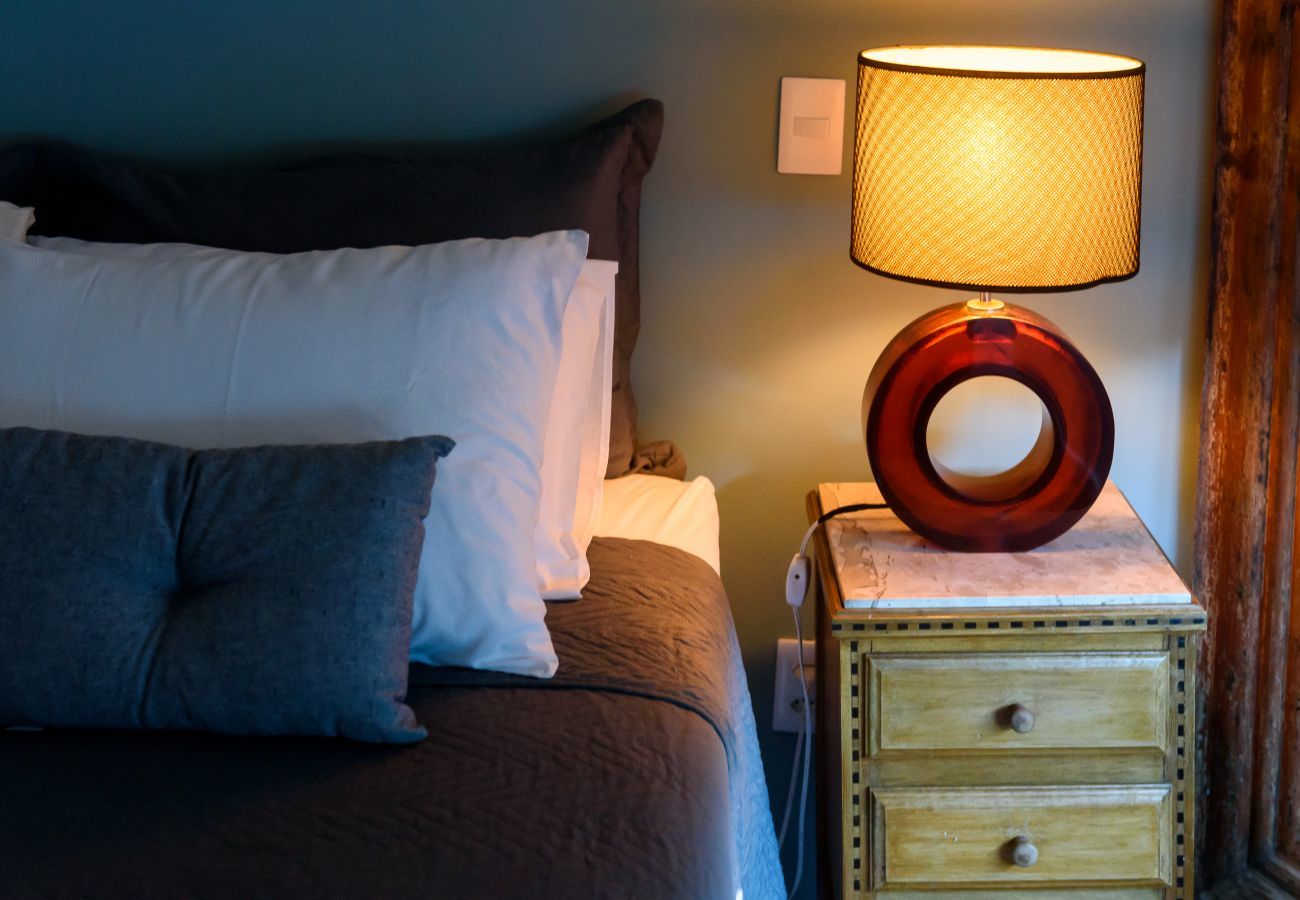 Dormitorio con cama de matrimonio y lámpara.